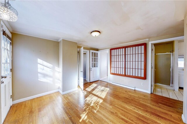 23 Sarah St, Providence, RI 02906 - foyer featuring a baseboard heating unit, wood-type flooring, baseboards, ornamental molding, and a chandelier