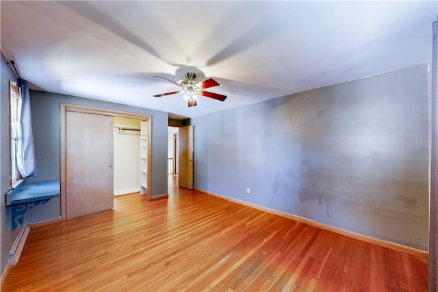 23 Sarah St, Providence, RI 02906 - unfurnished bedroom featuring light wood-type flooring, a closet, baseboards, a ceiling fan, and a baseboard heating unit