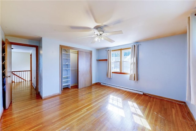 23 Sarah St, Providence, RI 02906 - unfurnished bedroom featuring a baseboard heating unit, a closet, light wood-type flooring, baseboards, and a ceiling fan