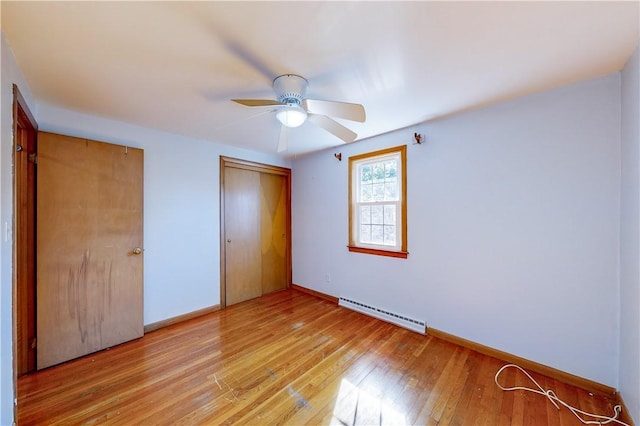23 Sarah St, Providence, RI 02906 - unfurnished bedroom with a baseboard heating unit, light wood-type flooring, a closet, baseboards, and ceiling fan