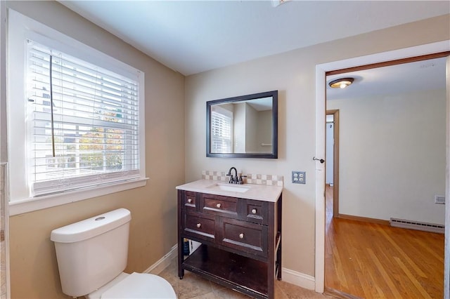 23 Sarah St, Providence, RI 02906 - bathroom featuring vanity, a baseboard radiator, toilet, baseboards, and wood finished floors