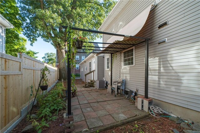 23 Sarah St, Providence, RI 02906 - fenced backyard with central AC unit, a patio, and entry steps
