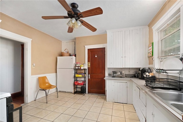 85 Englewood Ave, Pawtucket, RI 02860 - kitchen with freestanding refrigerator, light countertops, ceiling fan, white cabinets, and light tile patterned flooring