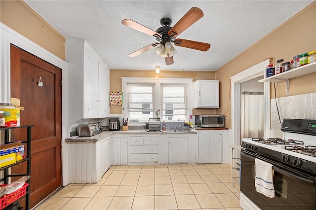 85 Englewood Ave, Pawtucket, RI 02860 - kitchen with gas range, stainless steel microwave, ceiling fan, light tile patterned floors, and white cabinets