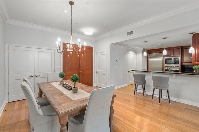 341 Thames St Unit 103, Bristol, RI 02809 - dining area with a chandelier, crown molding, light wood-type flooring, and baseboards