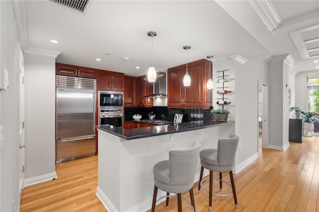 341 Thames St Unit 103, Bristol, RI 02809 - kitchen with built in appliances, backsplash, a peninsula, light wood-style flooring, and dark countertops