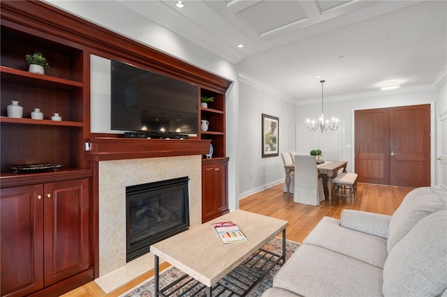 341 Thames St Unit 103, Bristol, RI 02809 - living area with crown molding, light wood-style floors, a premium fireplace, a chandelier, and baseboards