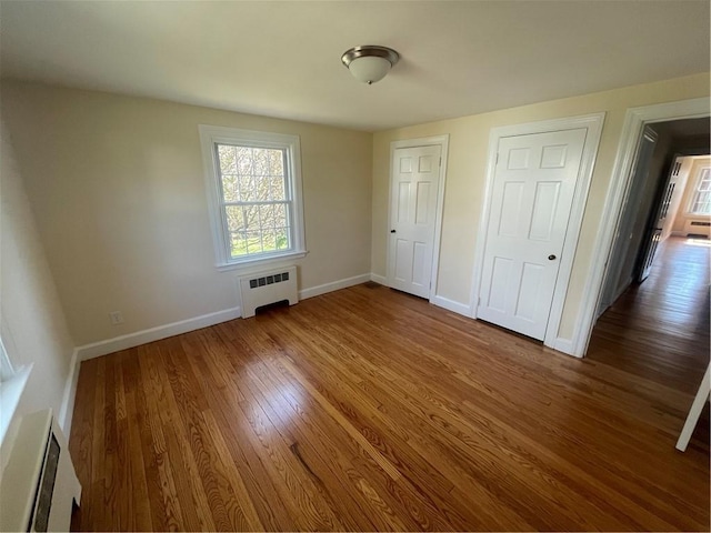 80 Frontier Rd, Warwick, RI 02889 - unfurnished bedroom featuring radiator, wood finished floors, and baseboards