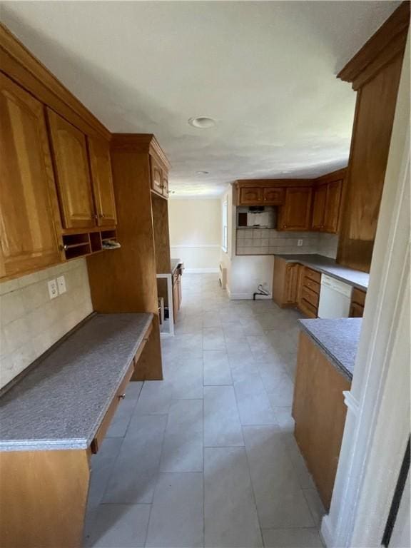 80 Frontier Rd, Warwick, RI 02889 - kitchen featuring backsplash, brown cabinetry, white dishwasher, and light tile patterned floors