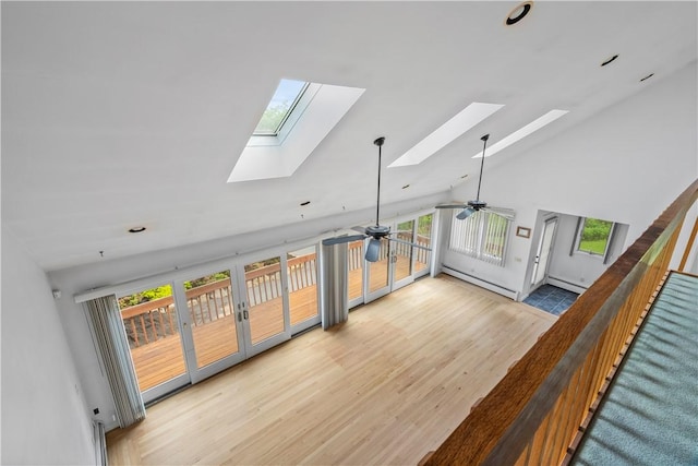 121 W Shore Dr, Exeter, RI 02822 - unfurnished living room featuring a skylight, light wood finished floors, a ceiling fan, a baseboard heating unit, and high vaulted ceiling