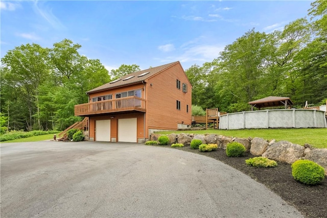 121 W Shore Dr, Exeter, RI 02822 - view of side of property with an attached garage, stairs, a wooden deck, and driveway