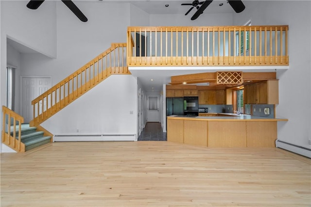 121 W Shore Dr, Exeter, RI 02822 - kitchen featuring ceiling fan, a towering ceiling, baseboard heating, wood finished floors, and open floor plan