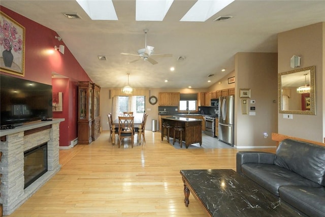 290 E View Ave, Cranston, RI 02920 - living area featuring vaulted ceiling, a skylight, baseboards, and light wood finished floors