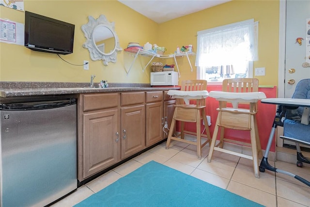 290 E View Ave, Cranston, RI 02920 - kitchen with dishwashing machine, white microwave, dark countertops, light tile patterned floors, and a sink