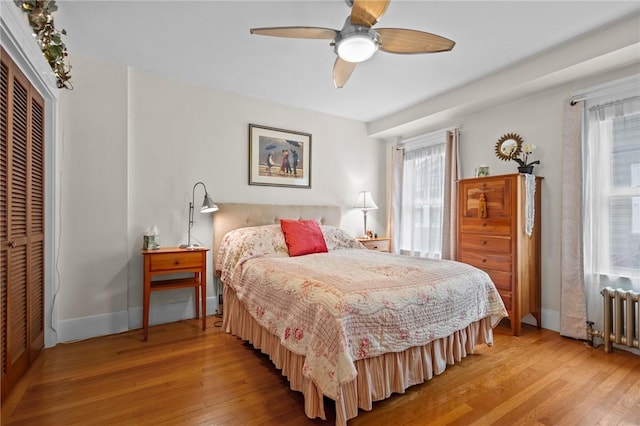 77 Friendly Rd, Cranston, RI 02910 - bedroom featuring radiator heating unit, light wood-style floors, baseboards, a closet, and ceiling fan