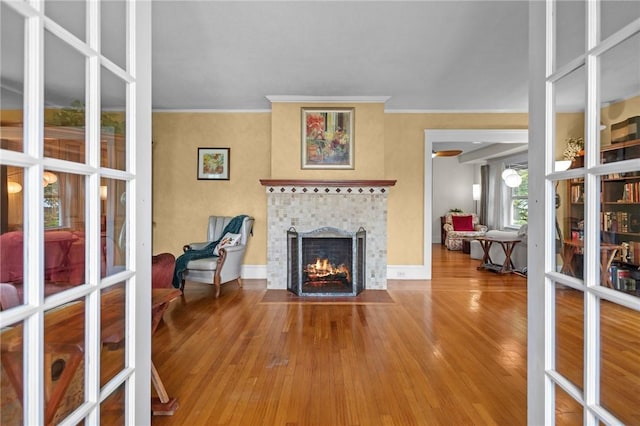 77 Friendly Rd, Cranston, RI 02910 - living area with french doors, ornamental molding, a fireplace with flush hearth, wood finished floors, and baseboards