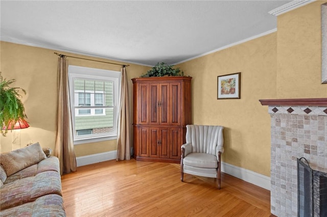 77 Friendly Rd, Cranston, RI 02910 - living room featuring light wood-style floors, a fireplace, ornamental molding, and baseboards