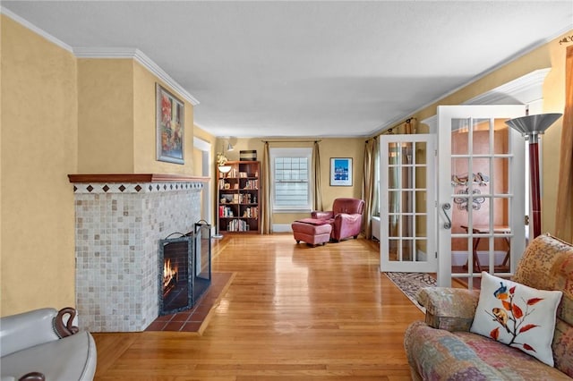 77 Friendly Rd, Cranston, RI 02910 - living room with wood finished floors, a tile fireplace, crown molding, and french doors
