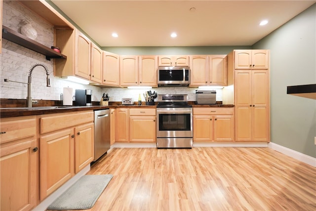 1 Tupperware Dr Unit 121, North Smithfield, RI 02896 - kitchen with stainless steel appliances, light brown cabinetry, open shelves, a sink, and dark countertops