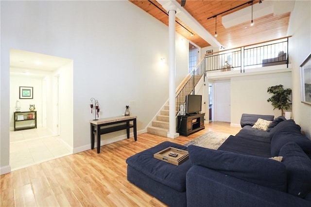 1 Tupperware Dr Unit 121, North Smithfield, RI 02896 - living area featuring high vaulted ceiling, stairs, wood ceiling with exposed beams, wood finished floors, and baseboards