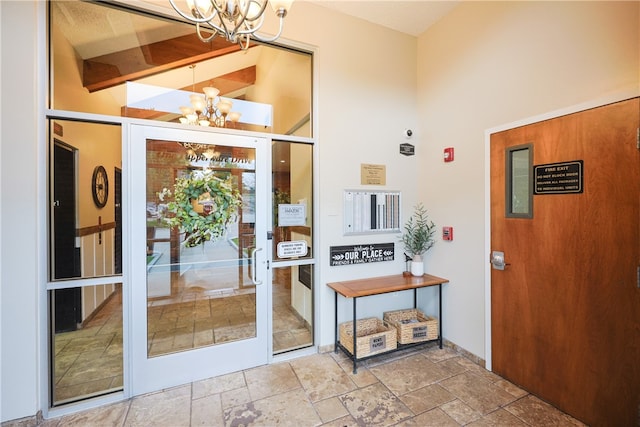 1 Tupperware Dr Unit 121, North Smithfield, RI 02896 - doorway to outside with a chandelier, stone tile floors, and a towering ceiling