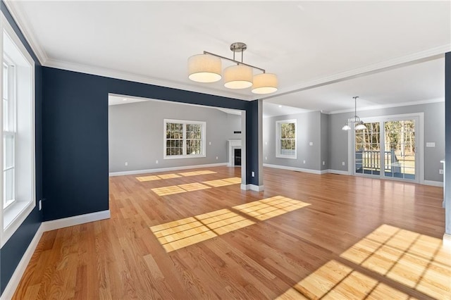 117 Mann School Rd, Smithfield, RI 02917 - unfurnished living room featuring a chandelier, baseboards, crown molding, and light wood-style flooring