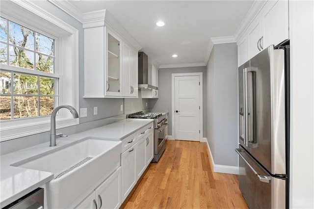 117 Mann School Rd, Smithfield, RI 02917 - kitchen with premium appliances, wall chimney exhaust hood, white cabinetry, light countertops, and crown molding