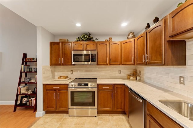 1 Tupperware Dr Unit 226, North Smithfield, RI 02896 - kitchen with stainless steel appliances, tasteful backsplash, brown cabinets, recessed lighting, and light wood-type flooring