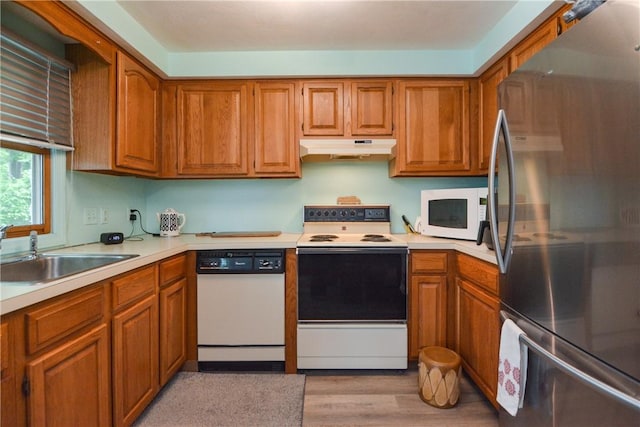 10 Leach St Unit B4, Cumberland, RI 02864 - kitchen with white appliances, under cabinet range hood, a sink, light countertops, and brown cabinetry