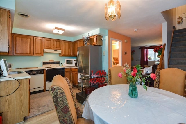 10 Leach St Unit B4, Cumberland, RI 02864 - kitchen featuring white appliances, under cabinet range hood, light countertops, light wood-style flooring, and brown cabinets