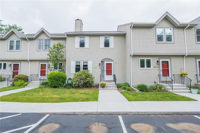 26 Noel Ct, South Kingstown, RI 02879 - multi unit property featuring a chimney, a front lawn, and uncovered parking