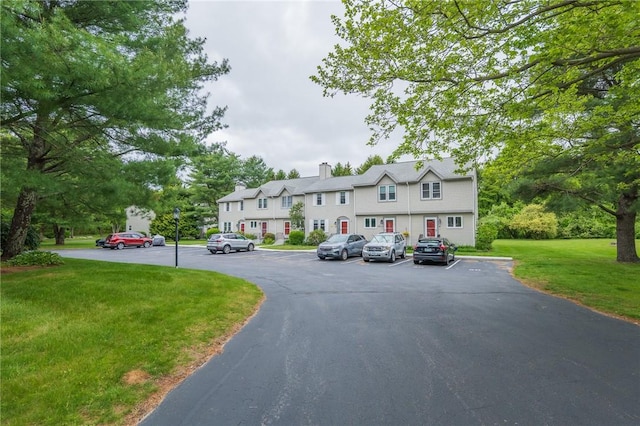 26 Noel Ct, South Kingstown, RI 02879 - view of front of home with uncovered parking, a front yard, and a chimney