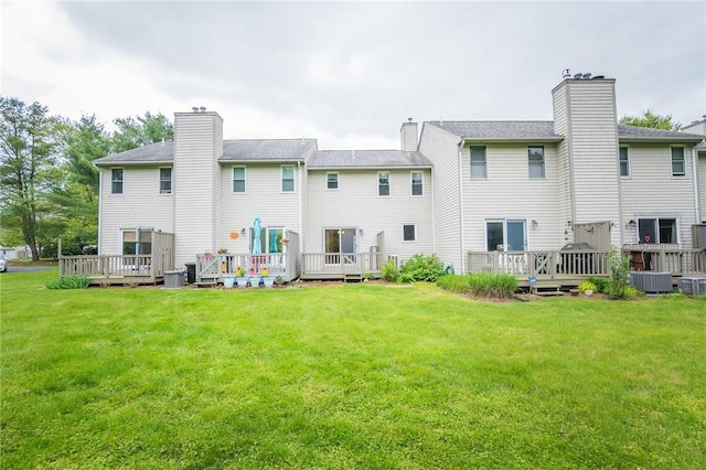 26 Noel Ct, South Kingstown, RI 02879 - back of house featuring a chimney, a wooden deck, and a lawn