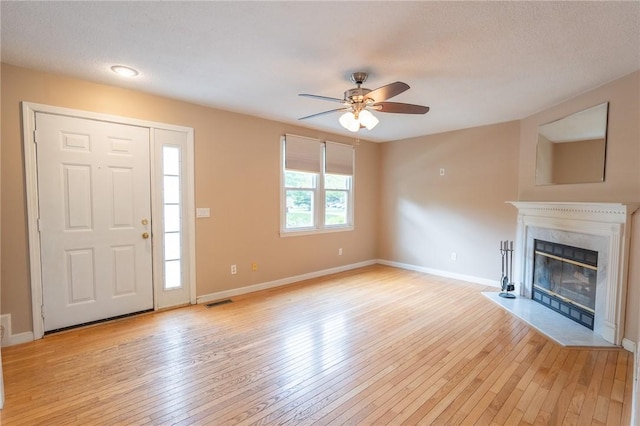26 Noel Ct, South Kingstown, RI 02879 - unfurnished living room with light wood finished floors, a ceiling fan, a high end fireplace, and baseboards