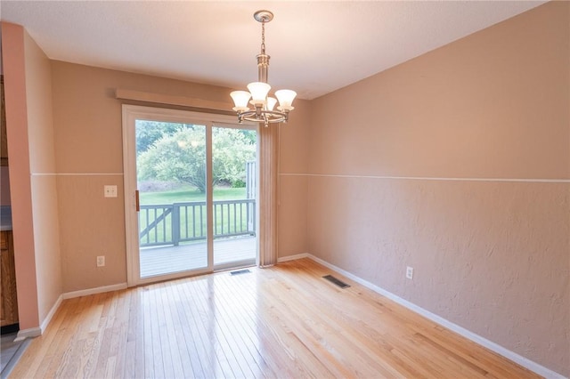 26 Noel Ct, South Kingstown, RI 02879 - empty room with light wood-style floors, a chandelier, baseboards, and a textured wall