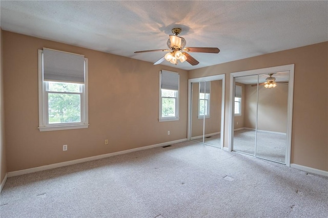 26 Noel Ct, South Kingstown, RI 02879 - unfurnished bedroom with two closets, multiple windows, and carpet floors