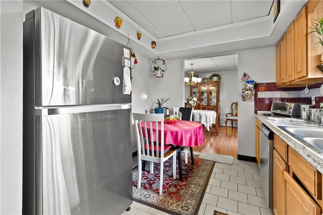 510 Child St Unit 105B, Warren, RI 02885 - kitchen with appliances with stainless steel finishes, a raised ceiling, light countertops, a chandelier, and light tile patterned floors