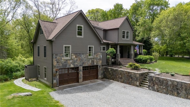 200 Miner Rd, North Kingstown, RI 02874 - view of front of house with stone siding, driveway, central AC, a garage, and a front yard