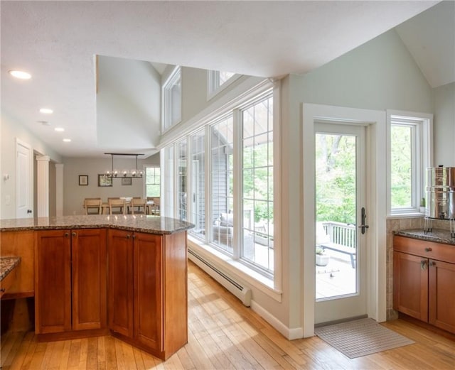 200 Miner Rd, North Kingstown, RI 02874 - kitchen with a baseboard heating unit, brown cabinetry, light wood-type flooring, recessed lighting, and vaulted ceiling