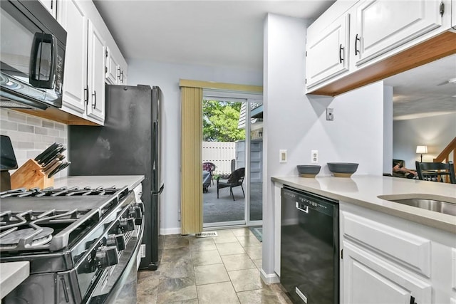 18 Caddy Rock Rd Unit C, North Kingstown, RI 02852 - kitchen featuring black appliances, light countertops, white cabinetry, and tasteful backsplash