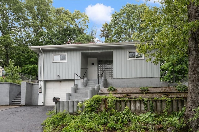 613 Prospect St, Woonsocket, RI 02895 - view of front of home featuring stairs, asphalt driveway, and a garage