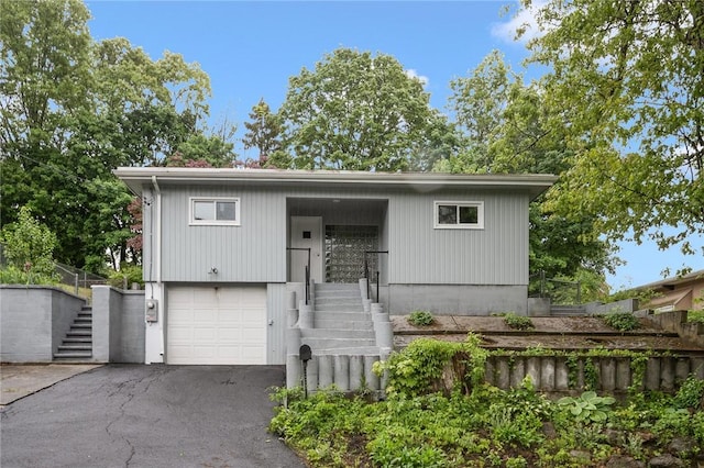 613 Prospect St, Woonsocket, RI 02895 - split foyer home with stairway, an attached garage, and driveway