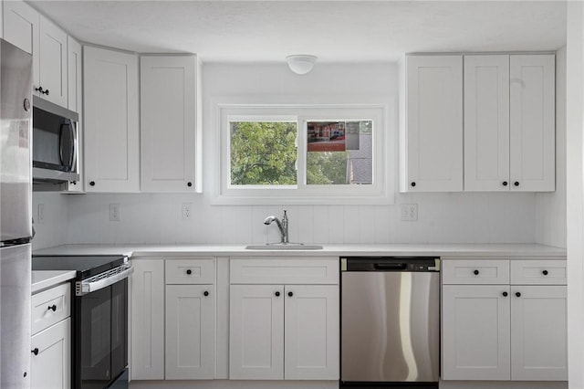 613 Prospect St, Woonsocket, RI 02895 - kitchen with appliances with stainless steel finishes, a sink, white cabinetry, and light countertops