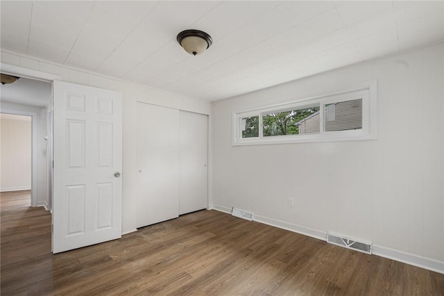 613 Prospect St, Woonsocket, RI 02895 - unfurnished bedroom with dark wood-type flooring, a closet, and baseboards