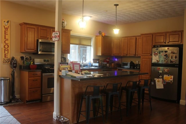 372 Mishnock Rd, West Greenwich, RI 02817 - kitchen featuring appliances with stainless steel finishes, a kitchen bar, dark wood-style flooring, and brown cabinets