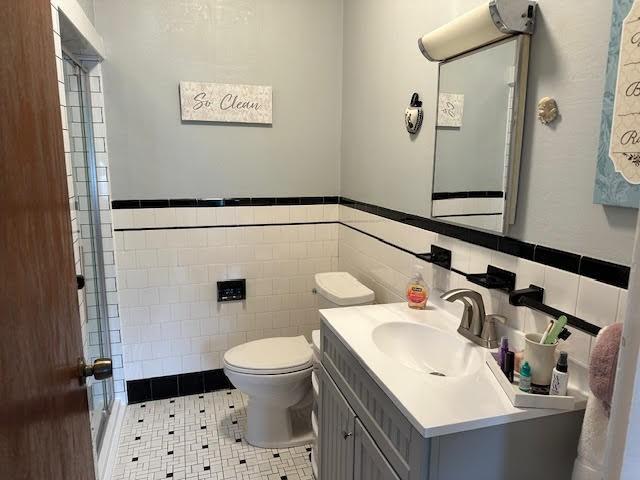 30 Pomham St, Cranston, RI 02910 - bathroom with tile walls, toilet, a stall shower, vanity, and wainscoting