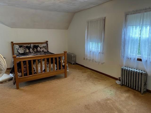 30 Pomham St, Cranston, RI 02910 - carpeted bedroom with radiator, vaulted ceiling, and baseboards