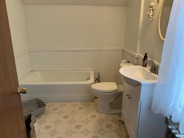 30 Pomham St, Cranston, RI 02910 - bathroom with vanity, a wainscoted wall, a tub to relax in, tile patterned floors, and toilet