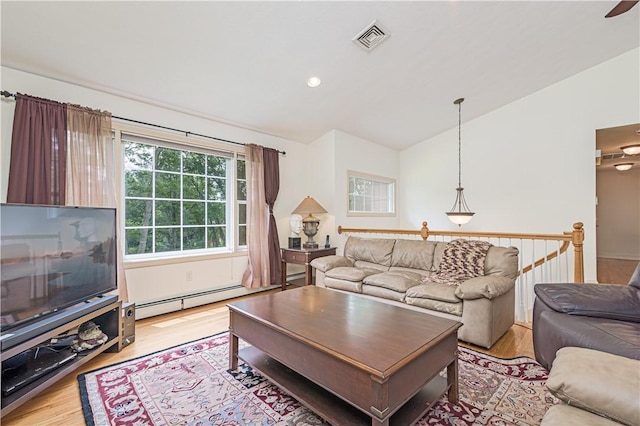 187 Plainfield Pike, Scituate, RI 02857 - living room with vaulted ceiling, light wood-type flooring, and a baseboard radiator