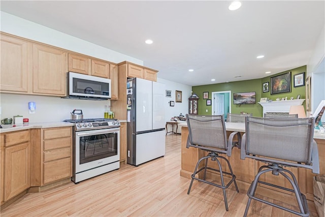 187 Plainfield Pike, Scituate, RI 02857 - kitchen featuring stainless steel appliances, light brown cabinets, light wood-style floors, recessed lighting, and light countertops